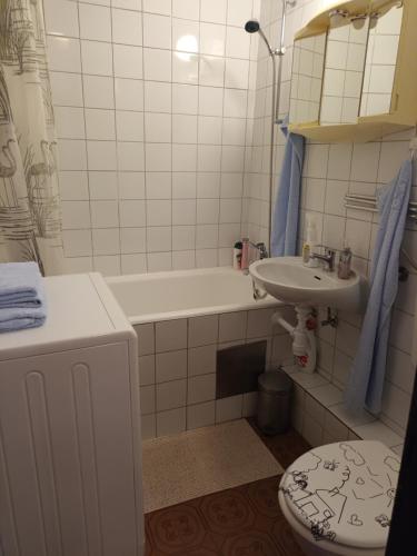 een badkamer met een wastafel, een toilet en een bad bij Studio apartman Lucija in Novi Zagreb