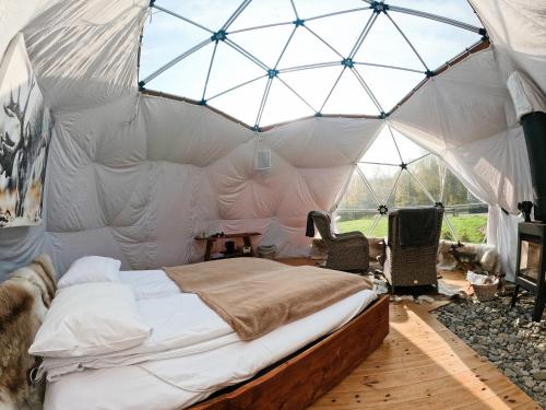 a bedroom with a large bed in a tent at Wild Caribou Dome in Lakselv