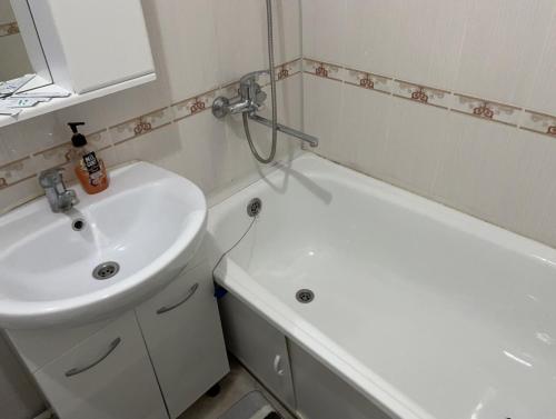 a bathroom with a sink and a toilet and a tub at Однокомнатная квартира в Жилгородке рядом с ДостарМед in Atyrau