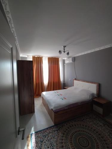 Habitación pequeña con cama y ventana en 2-х комнатная квартира en Kyzylorda