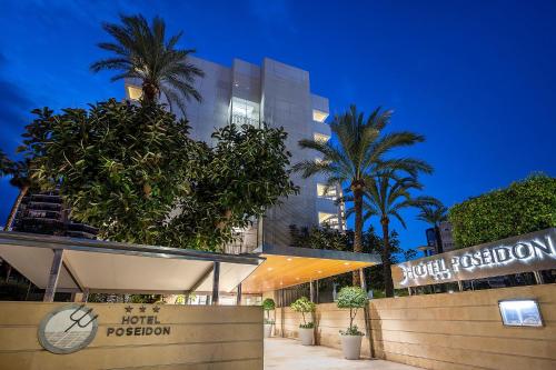 a building with palm trees in front of it at Poseidon Resort in Benidorm