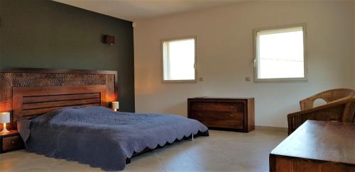 a bedroom with a bed and two windows at Domaine de La Font des Pères - Teritoria in Le Beausset