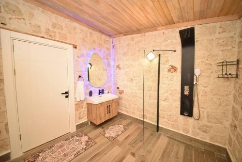 a bathroom with a walk in shower and a sink at KYANEAİ VİLLA in Demre