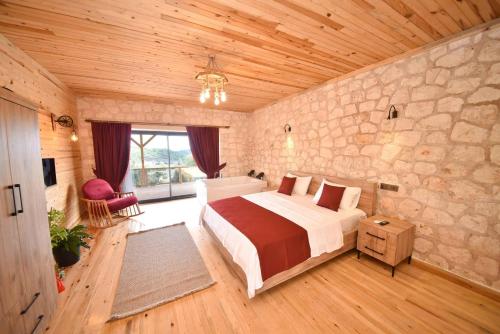 a bedroom with a large bed and a stone wall at KYANEAİ VİLLA in Demre