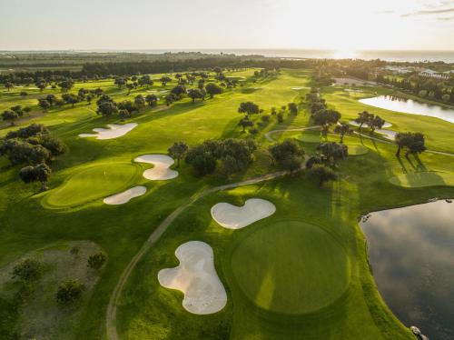 an overhead view of a golf course with three putting greens at ROBINSON QUINTA DA RIA - All Inclusive in Vila Nova de Cacela