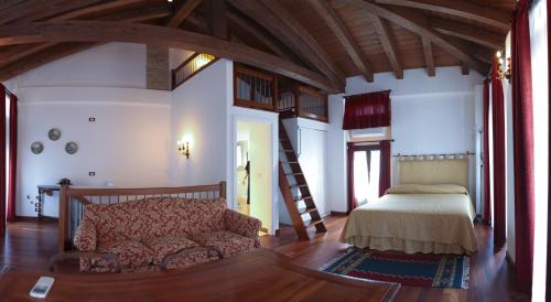 ein Wohnzimmer mit einem Sofa und einem Bett in der Unterkunft Casa Filaferro in Palazzolo dello Stella