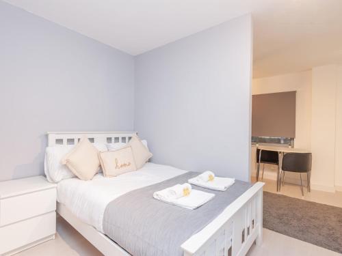 a white bedroom with a white bed and a table at Pass the Keys City Centre Haven in Leeds