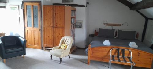 a bedroom with a wooden bed and a chair at The Old Court House Guest House in Ross on Wye