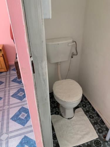 a bathroom with a toilet in a small room at A house , Akan trust in Cape Town