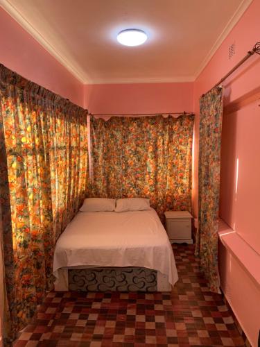 a bedroom with a bed in a room with curtains at A house , Akan trust in Cape Town