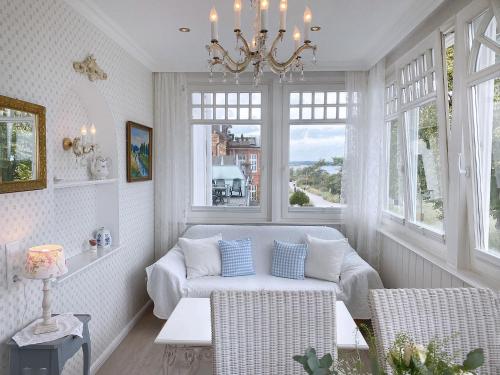 uma sala de estar com um sofá e um lustre em Villa Hansa am Meer em Timmendorfer Strand