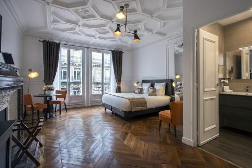 1 dormitorio con 1 cama, mesa y sillas en Vestay George V, en París