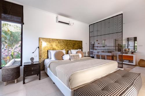 a bedroom with a large bed and a large window at Villa Plumeria - Walk to Bingin Beach in Uluwatu