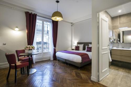 a bedroom with a bed and a table and a sink at Vestay George V in Paris