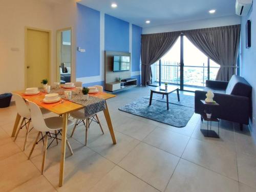 a dining room and living room with a table and chairs at JZstay - Atlantis Residences Melaka - 1BR & 2BR in Melaka
