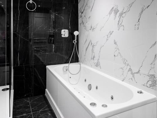 a black and white bathroom with a tub and a shower at Dover Marina Hotel & Spa, Tapestry Collection by Hilton in Dover