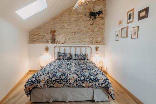 a bedroom with a bed and a brick wall at Grange Petite Brise bord de mer in Luc-sur-Mer