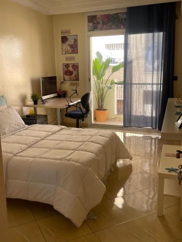 Schlafzimmer mit einem Bett, einem Schreibtisch und einem Fenster in der Unterkunft Private room in Casablanca