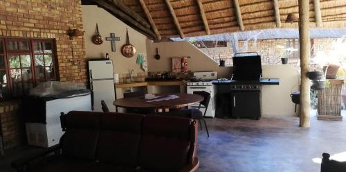 een keuken met een tafel, een fornuis en een koelkast bij THE ORCHID GUESTHOUSE 