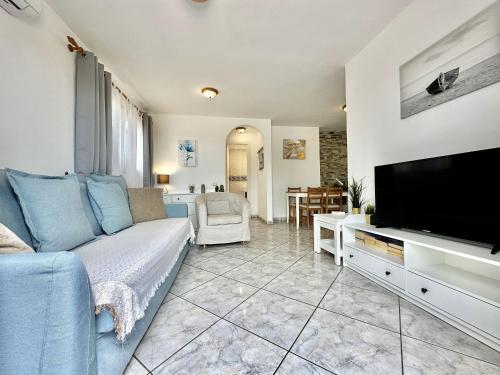 a living room with a blue couch and a flat screen tv at Vista Bonita, Golf del Sur in San Miguel de Abona