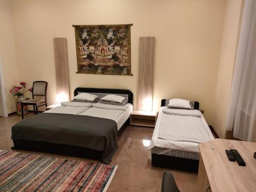 ブダペストにあるMarxim Apartmentsのベッドルーム1室(ベッド2台、テーブル付)