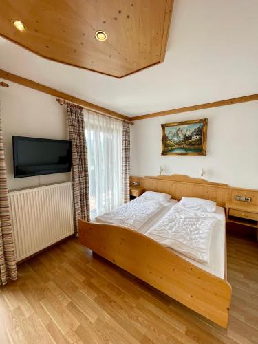 a bedroom with a bed and a flat screen tv at Ferienwohnung Almblick in Reit im Winkl