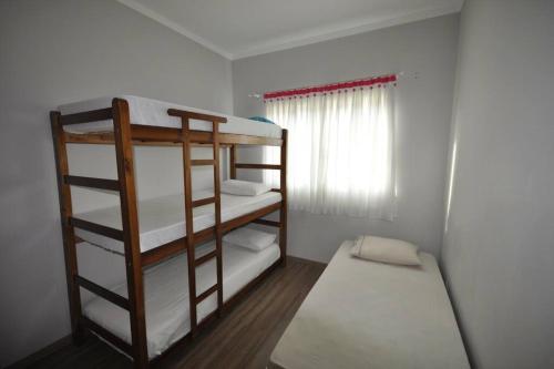 波蘇斯迪卡爾達斯的住宿－Apto com 3 quartos,1 vaga garagem e quintal，客房设有两张双层床和一扇窗户。