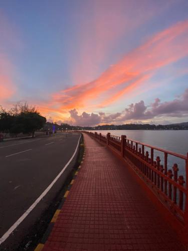 a road with a fence next to a body of water at Hibiscus Home Stay & Boutique in Port Blair