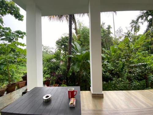 a wooden table with a cup of coffee on a porch at Hibiscus Home Stay & Boutique in Port Blair