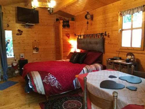 1 dormitorio con 1 cama en una cabaña de madera en Au Cabanon Chez Nath - chbre d'hôtes - gîte, en Varages