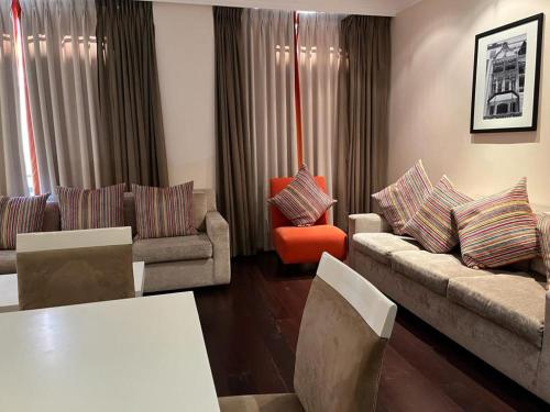 a living room with couches and a table and chairs at Mandela Rhodes Place in Cape Town