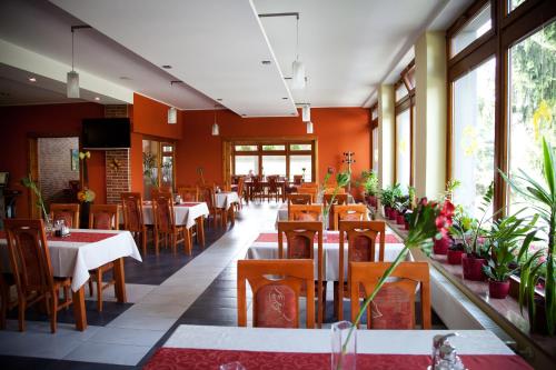 a restaurant with tables and chairs and windows at Motel Skalka in Radola