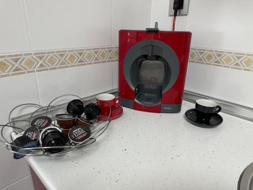 Un mostrador con tostadora y tazas. en Piso familiar en El Toyo, en Almería
