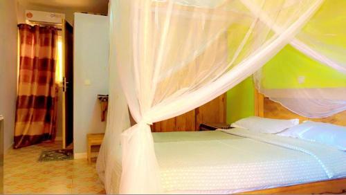 a bedroom with a bed with white mosquito netting at Africa 6 Plage in Somone