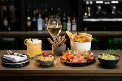 a table topped with bowls of food and a glass of wine at CH Longstay 2 in Kortrijk