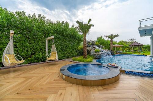 a backyard with a swimming pool and a swing at StayVista at Serenity Farms with Pool, Lawn, Bonfire & BBQ in Sohna
