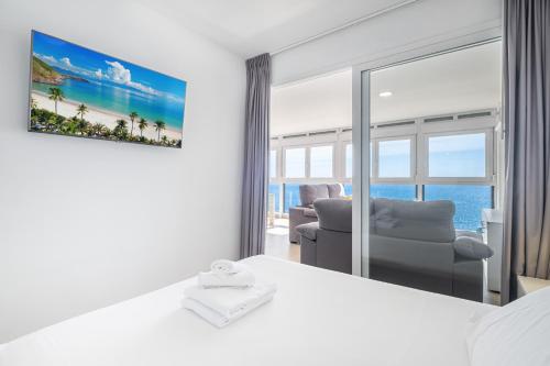 - une chambre avec un lit, une chaise et une fenêtre dans l'établissement Santa Margarita Deluxe 14-B Levante Beach, à Benidorm