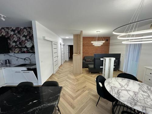 a kitchen and living room with a table and chairs at Apartament na Irysowej in Dobrzeń Wielki