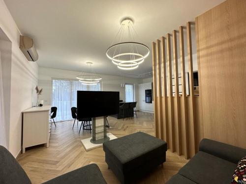 a living room with a television and a living room with a table at Apartament na Irysowej in Dobrzeń Wielki