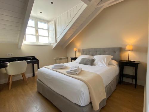 a bedroom with a large bed and a piano at La Reserva de Los Campos in Cadavedo