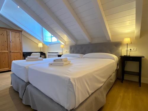 a bedroom with two beds with white sheets at La Reserva de Los Campos in Cadavedo
