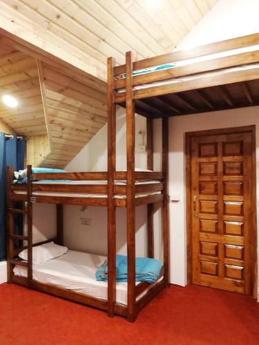 two bunk beds in a room with a door at Utopia Hostels Dharamkot Mcleodganj in Dharamshala