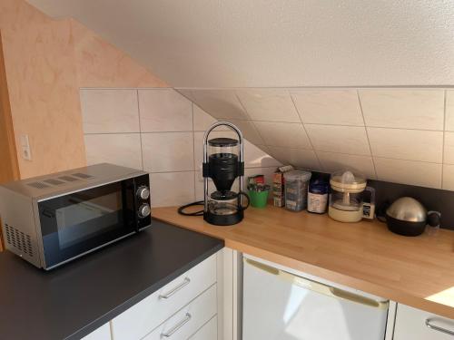 a kitchen counter with a microwave on a counter top at Ferienwohnung am Nordwald , Saterland in Sedelsberg