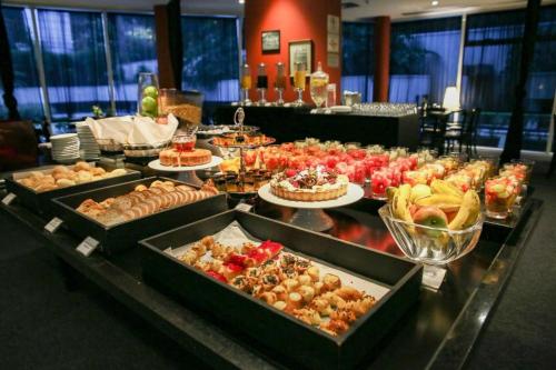 a buffet line with many different types of food at King room - Brooklin flat in Sao Paulo