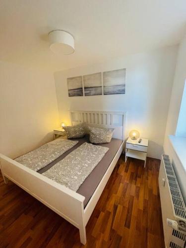 a large bed in a room with a wooden floor at Zentrale Altstadtkoje für bis zu 6 Personen in Neustadt in Holstein