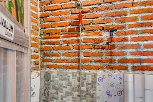 a brick wall with a water hose attached to it at OYO Life 93010 Omah Bareng Syariah Sambisari in Kalasan