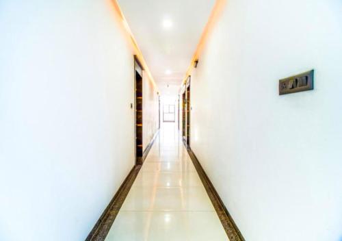 a hallway in a building with white walls and tile floors at Hotel Deepali Executive in Aurangabad