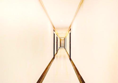 an empty corridor in a white building with a long hallway at Hotel Deepali Executive in Aurangabad