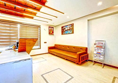 a living room with a brown leather couch in it at Hotel Deepali Executive in Aurangabad