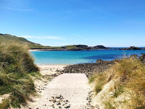 a path leading to a beach with a body of water at The Georgian House in Alderney